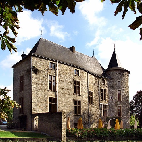 Kasteel met een terras en gele parasols (ingeklapt).