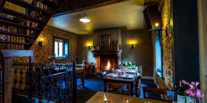 De tafelindeling met openhaard en kaarsjes bij Auberge de Smockelaer